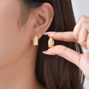 Vue détaillée de boucles d'oreilles en U dorées avec pavage de zircons blancs