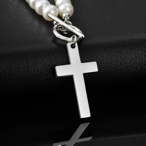 Detail view of pearl necklace with silver cross pendant and OT buckle on leather