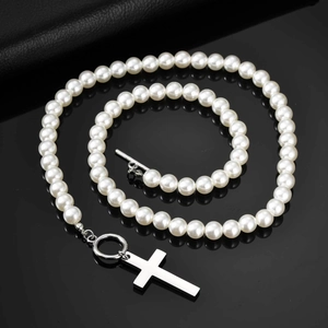 Detailed macro of a stainless steel cross pendant on a white imitation pearl necklace