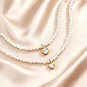Double layered pearl necklace set with heart and round gold zircon pendants on silk