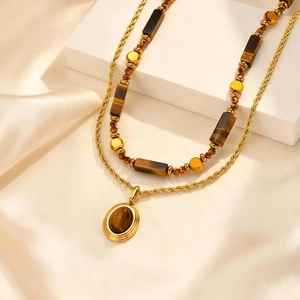 Détail macro du collier double couche avec pendentif œil de tigre et maillons torsadés