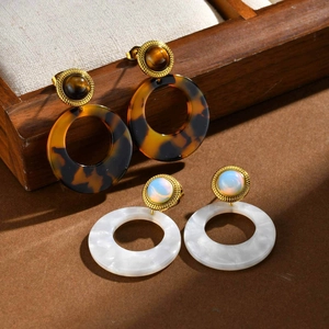 Vintage stainless steel round drop earrings with tiger eye and opal stones on wood tray