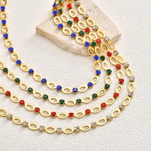 Detail van 18K vergulde kettingen met kleurrijke strass-steentjes op stenen basis