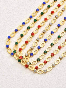 Detailopname van een vergulde ovale ketting met kleurrijke strassteentjes in een S-curve