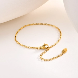 Nahaufnahme eines goldenen Edelstahl-Armbands mit K18-Gravur und Karabinerverschluss