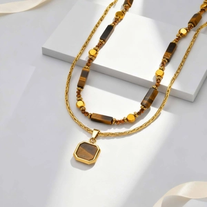 Détail du collier double rang en acier avec pendentif œil de tigre et perles