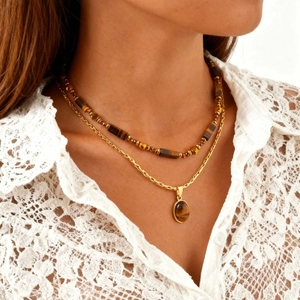 Détail du collier à plusieurs rangs avec pendentif en œil de tigre et chaîne torsadée
