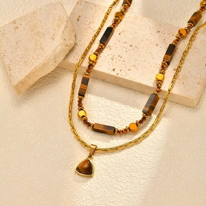 Détail du collier double couche doré avec perles d'œil de tigre et pendentif triangle