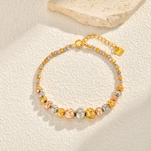 Detailed macro of tricolor faceted metal beads bracelet with heart charm and lobster clasp