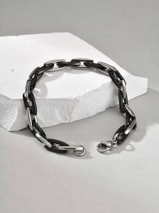 Silver stainless steel and black ceramic Cuban chain link bracelet on white stone