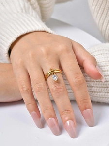 Gros plan d'une bague double en acier inoxydable doré avec zircon poire au doigt