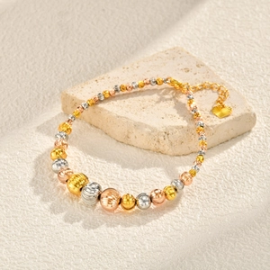 Three-tone gold, silver, and rose gold bead bracelet with heart charm and faceted texture