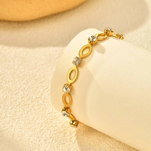 Macro-opname van gouden armband met witte kristallen strassteentjes en ovale schakels
