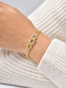 Macro detail of gold-plated cuban link bracelet with zircon encrusted oval rings