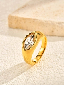 Macro detail of gold marquise cut cubic zirconia ring on a natural stone surface