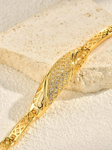Macro shot of 24K gold plated bracelet featuring hollow patterns and crystal pavé details
