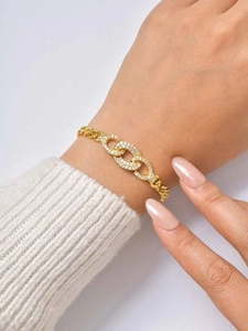 Detailed close-up of gold-plated interlocking oval rings with micro-pave cubic zirconia stones