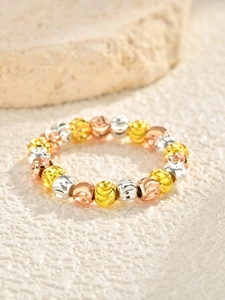 Macro detail of tricolor metallic beaded ring with spiral textured surface on stone base