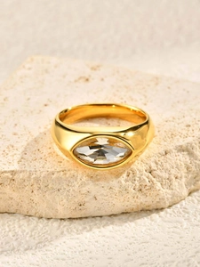 Macro detail of gold marquise cut zircon ring on natural stone for elegant style