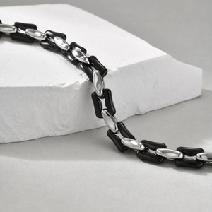 Macro shot of industrial style black high-gloss and silver cuban link chain for men