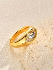 Macro shot of gold stainless steel ring featuring a large oval marquise white zircon