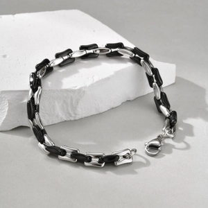 Detail of silver link bracelet with black resin inserts and lobster clasp on stone