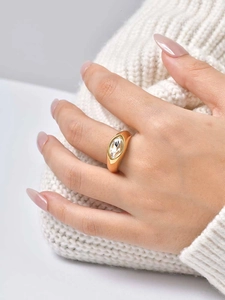 Detail of gold marquise-cut zircon ring on model hand with cozy knit sweater background