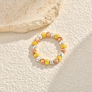 Macro shot of three-tone faceted metal beads ring in gold silver and rose gold finish