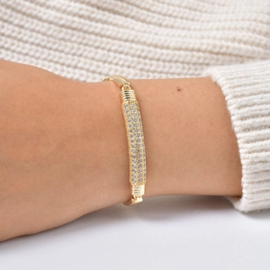 Detail of gold zircon bracelet with pavé rectangle piece and spiral textured accents