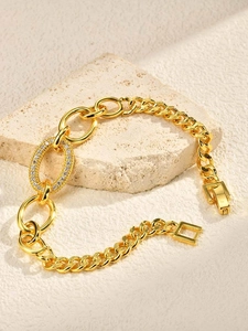 Macro view of gold chain bracelet with micro-pave cubic zirconia oval link and clasp