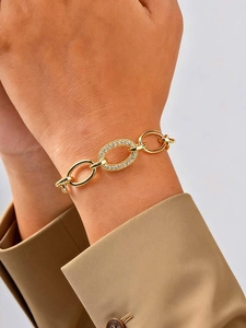 Close-up of gold chain bracelet with micro-paved zircon oval link on woman wrist