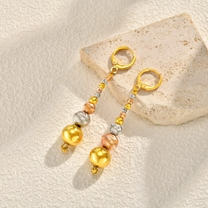 Close-up of tricolor beaded drop earrings with polished and textured metallic finish