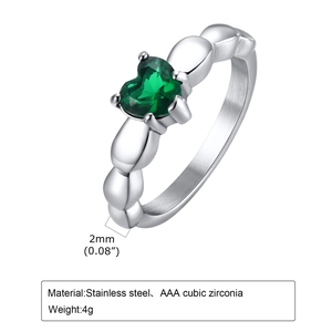 Détail de l'anneau en acier de 2 mm et du zircon vert en forme de cœur sur la bague