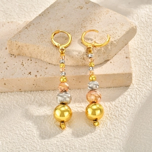 Detailed view of tricolor faceted watermelon bead earrings on stone background