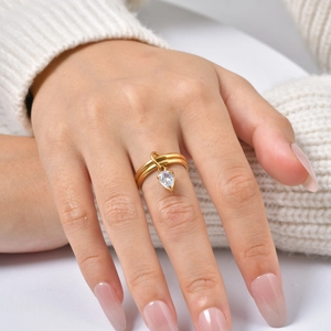 Bague double couche en acier doré avec pendentif goutte en zircon blanc portée par mannequin