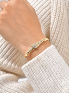 Close-up of elegant gold heart bracelet with pavé cubic zirconia worn on a model's wrist