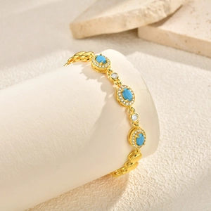 Bracciale placcato oro 24K con pietre blu ovali e accenti di zirconi scintillanti