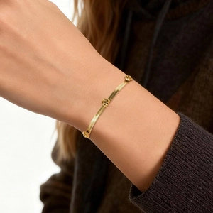On-model view of a gold-plated stainless steel snake chain bracelet with rose charms