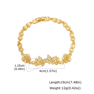 Detailed view of 24K gold plated bracelet with infinity flower charms and zirconia stones