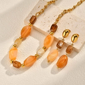 Irregular resin and gold bead necklace set with matching drop earrings on stone