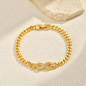 Close-up of golden Cuban link bracelet featuring a zircon-studded infinity symbol charm