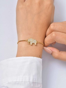 Close-up of golden elephant bracelet set with white zircon stones on a female wrist