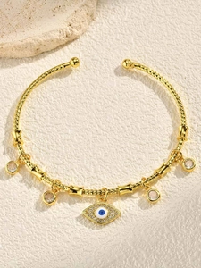 Detailed view of golden evil eye bangle with lattice pattern and clear zircon charms