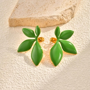 Detailed macro view of golden leaf stud earrings with vibrant green enamel coating