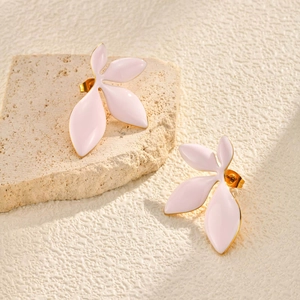 Detail shot of light pink leaf-shaped earrings with gold metal edges on stone props