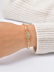 Macro detail of 24K gold-plated infinity bracelet with pave zircon and lobster clasp
