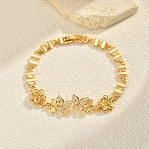 Detailed close-up of 24K gold-plated infinity bracelet with zircon floral and butterfly charms