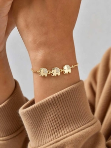 Detail of gold elephant bracelet with pave zircon pendants on model wrist