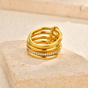 Macro shot of gold multi-layered stackable ring with pavé zircons and a small ring charm