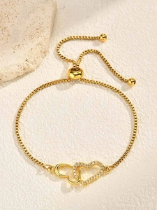 Macro shot of gold-plated double interlocking hearts bracelet with sparkling zircons